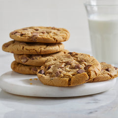 Stack of cookies on a plate with a glass of milk