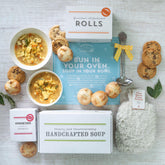 Pregnancy Care Package with soup, rolls, cookies, a fuzzy old fashioned heat pack, and a insert with text "Bun in your oven, soup in your bowl"