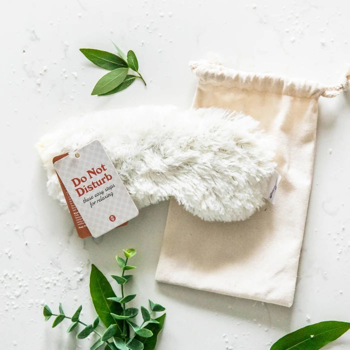 White faux fur eye mask with tag with text "Do Not Disturb" and canvas product bag.