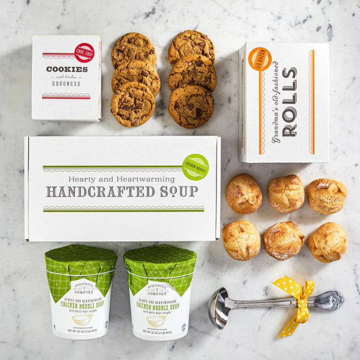 Spoonful of Comfort package layed out on a counter with soup, rolls and cookies