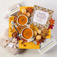 Overhead image displaying "Warm Autumn Wishes" card, Spoonful of Comfort Box, styled with soups, rolls and cookies.