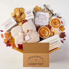 Overhead image displaying "Warm Autumn Wishes" card, Spoonful of Comfort Box, styled with soups, rolls and cookies.